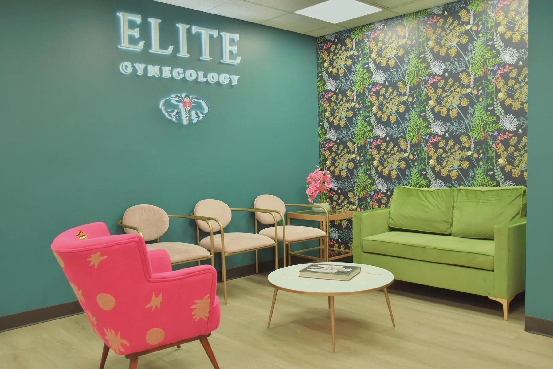 The Elite Gynecology waiting room at 800 Second Avenue, with a coral armchair, a green sofa and the botanical wallpaper